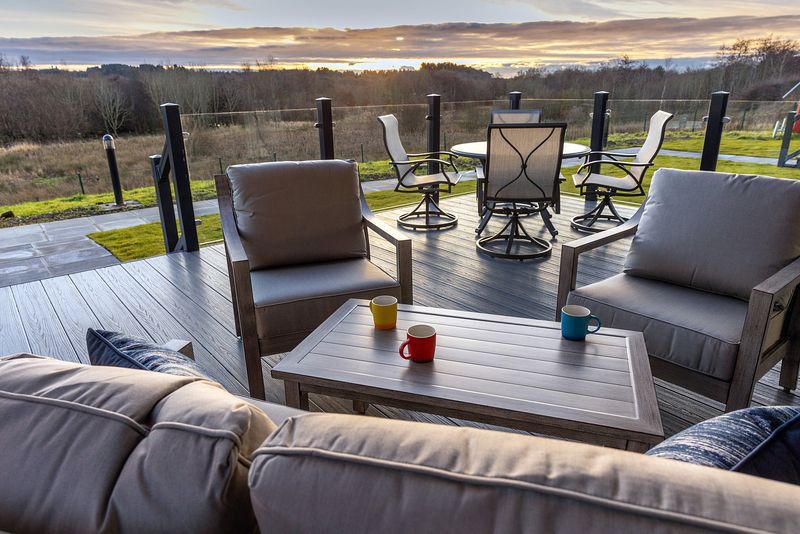 Deck area with furniture, mugs on a table and a view of a natural landscape beyond